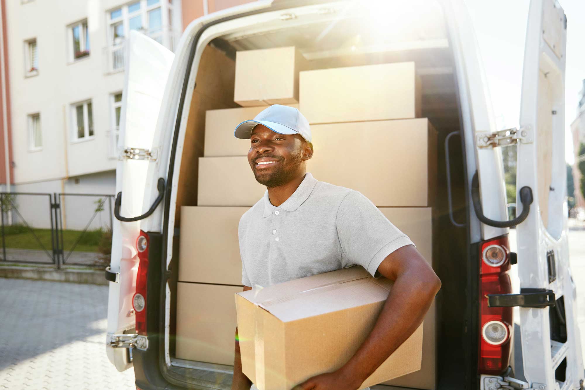 Delivery man. Молодой человек держит платёжный терминал. Доставке фотографии клиентам. Костюм курьера. Black delivery.